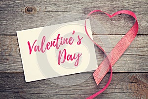 Blank valentines greeting card and red heart shaped ribbon