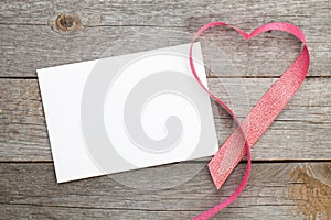 Blank valentines greeting card and red heart shaped ribbon