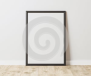 Blank Vertical black frame on wooden floor with white wall, 3:4 ratio, 30x40 cm, 18x24 inches, poster frame mock up, 3d rendering.