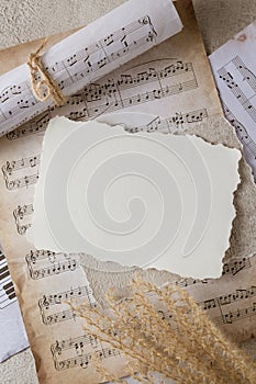 Blank vintage paper card on aged music notes background. Empty grunge postcard with copy space