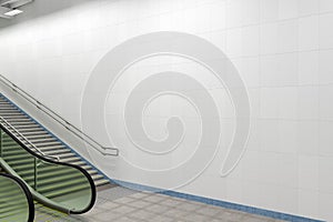 Blank wall mock up underground with escalator and stairs