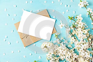 Blank wedding greeting card or invitation with spring blossom cherry flowers on pastel blue background. Mock up