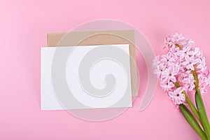 Blank wedding invitation stationery card mockup with envelope on pink background with hyacinth flowers