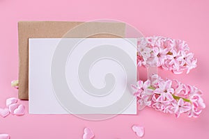 Blank wedding invitation stationery card mockup with envelope on pink background with hyacinth flowers and pink heart