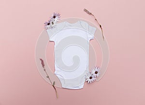 Blank white baby bodysuit mockup surrounded by pretty pink flowers