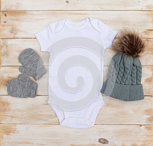 Blank white babygrow winter mock up on white washed wood background