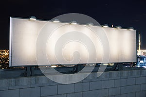 Blank white billboard on the top of building at night city background, mock up