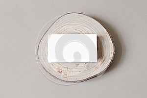 Blank white business card mockup on wooden plate, chop board. Grey table backgound. Modern minimalist template. Branding