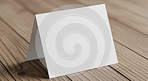 Blank white card standing upright on a light brown wooden surface with subtle shadows