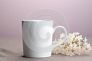 a blank white ceramic coffee mug nex to a bunch of flowers