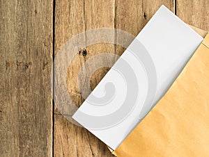Blank white document paper in openning brown paper envelope photo