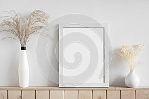 Blank white empty picture frame mockup on white wall. Home staging and minimalism concept.