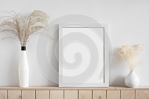 Blank white empty picture frame mockup on white wall. Home staging and minimalism concept. photo