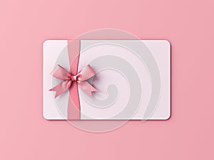 Blank white gift card or gift voucher with pink ribbon bow isolated on pink pastel color background