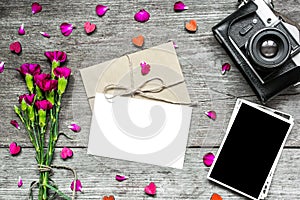 Blank white greeting card with blank photo and retro camera with flowers
