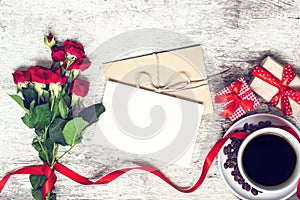 Blank white greeting card and envelope with coffee cup and red roses