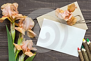 Blank white greeting card with tender iris flowers bouquet and envelope