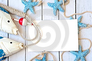 Blank white greeting card with white Starfish and seashells on blue small stone pebbles