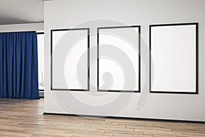 Blank white mock up posters on white wall in modern empty room with wooden floor and blue curtain