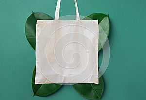 Blank white mockup linen cotton cloth tote bag on green leaves foliage background. Zero waste reusable nature friendly materials
