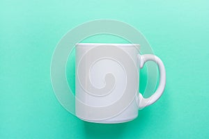 Blank White Mug Mockup on Light Turquoise Background. Template Space for Creative Artwork Lettering