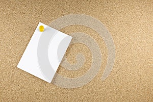 Blank white note papers is pinned to a cork board