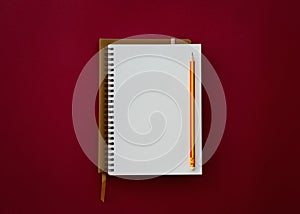 Blank white notepad with pencil  on red paper background