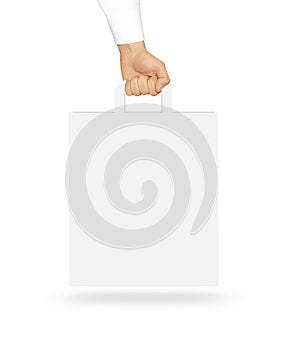 Blank white paper bag mock up holding in hand. Empty plastic pac