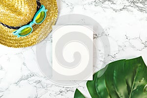 Blank white paper card on marble table top view with summer beach accessories monstera leaves ,Summer vacation concept,Mock up te