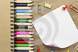blank white paper note with school office supplies on wood desk.