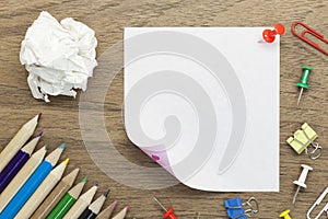 blank white paper note with school office supplies on wood desk.