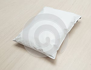 Blank white plastic bag package mockup template on wooden background.