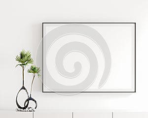 Blank white poster frame, black frame in the livingroom, elegant simple white wall, modern display cabinet, table top, white book,
