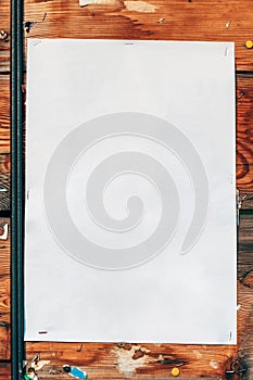 Blank white poster paper mockup stapled to a wooden background