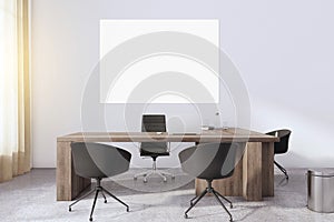 Blank white poster with space for your text on light wall in sunny cabinet with stylish workspace: wooden table, modern chairs,