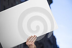 Blank White Protest Sign Hand with Urban Background