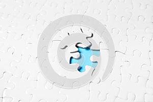 Blank white puzzle with separated piece on blue background