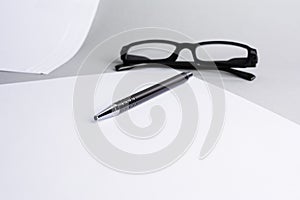 Blank white sheet of paper with pen, glasses photo