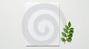 A blank white sheet of paper is placed on a white surface, accompanied by a small