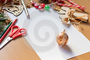 Blank white sheet of paper surrounded with festive christmas decorations. Merry Christmas and Happy New Year. Xmas concept. Top