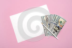 blank white sheet of paper with white pencil and money banknotes on pink background