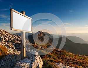 Blank white sign on a mountain with sky background