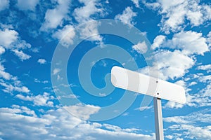 Blank white signpost against blue sky with clouds photo