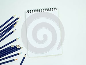 Blank white spiral bound paper drawing pad with color pencil. Is