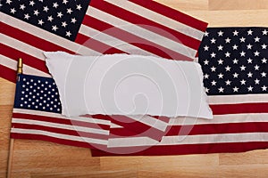 Blank white torn pieces of paper laying on three American flags