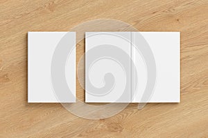 Blank white vertical closed and open and upside down book cover on wooden background isolated with clipping path around cover.