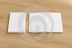 Blank white vertical closed and open and upside down book cover on wooden background isolated with clipping path around cover.