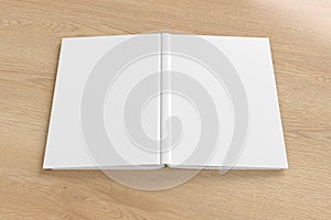 Blank white vertical open and upside down book cover on wooden background isolated with clipping path around cover.