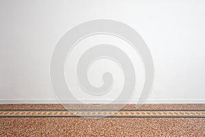 Blank white wall and ancient tiled floor with decoration