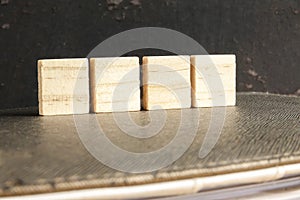 Blank wood scrabble pieces isolated on grunge black background.